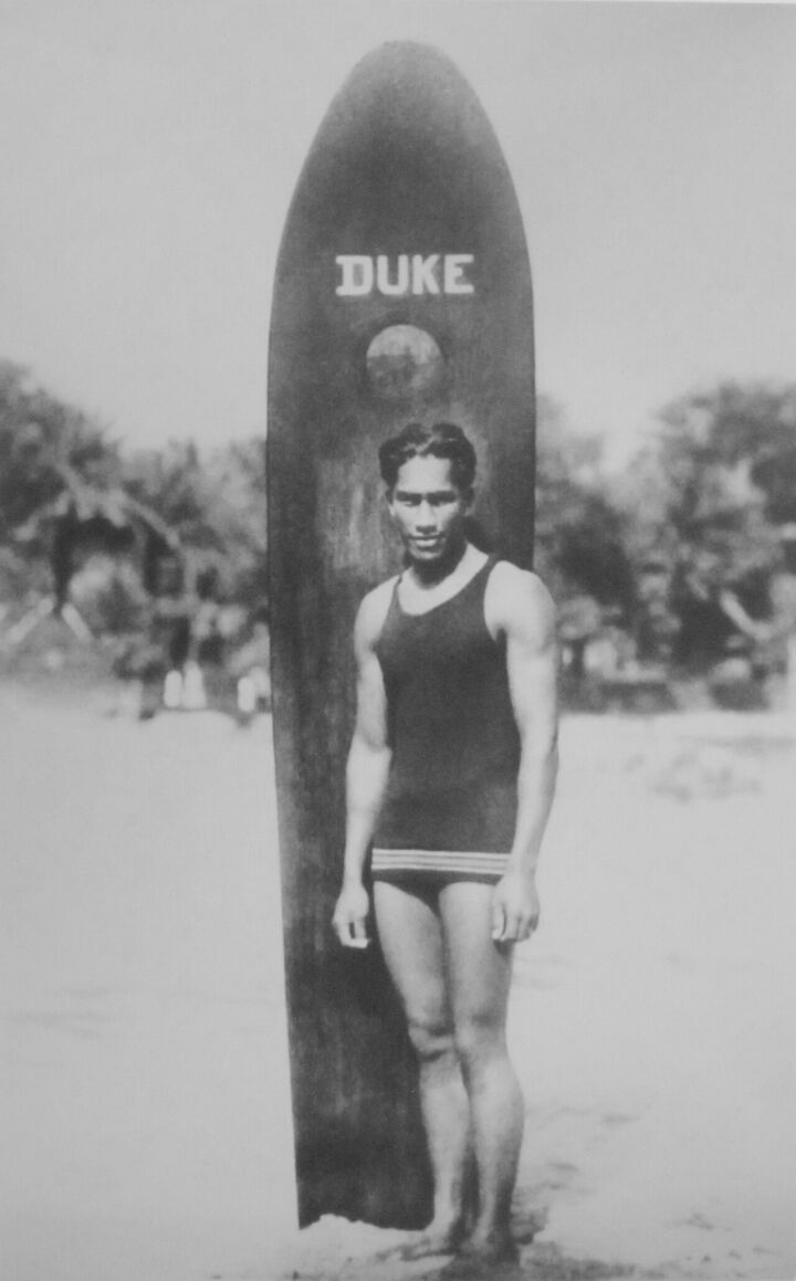 Duke Kahanamoku con su tabla de madera maciza, a principios del siglo XX.